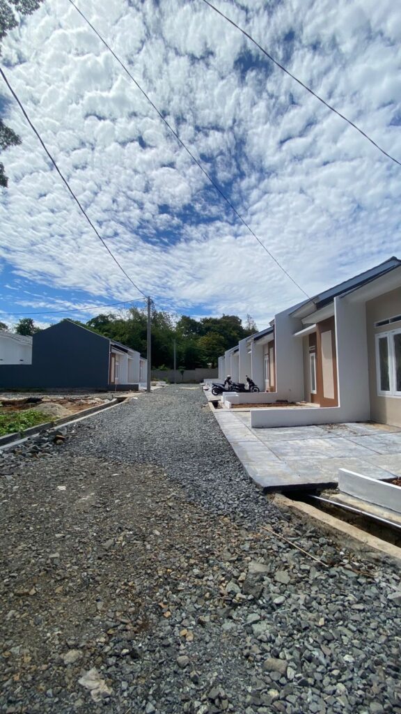 Deretan rumah subsidi di Tangerang tipe 30/60 bergaya minimalis modern, dalam proses pembangunan, berada di lingkungan hijau dengan akses jalan yang luas.
